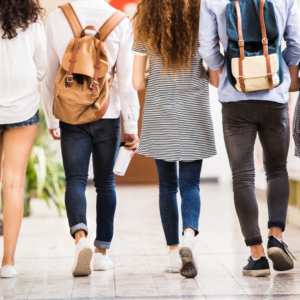 Four young people walking away from camera